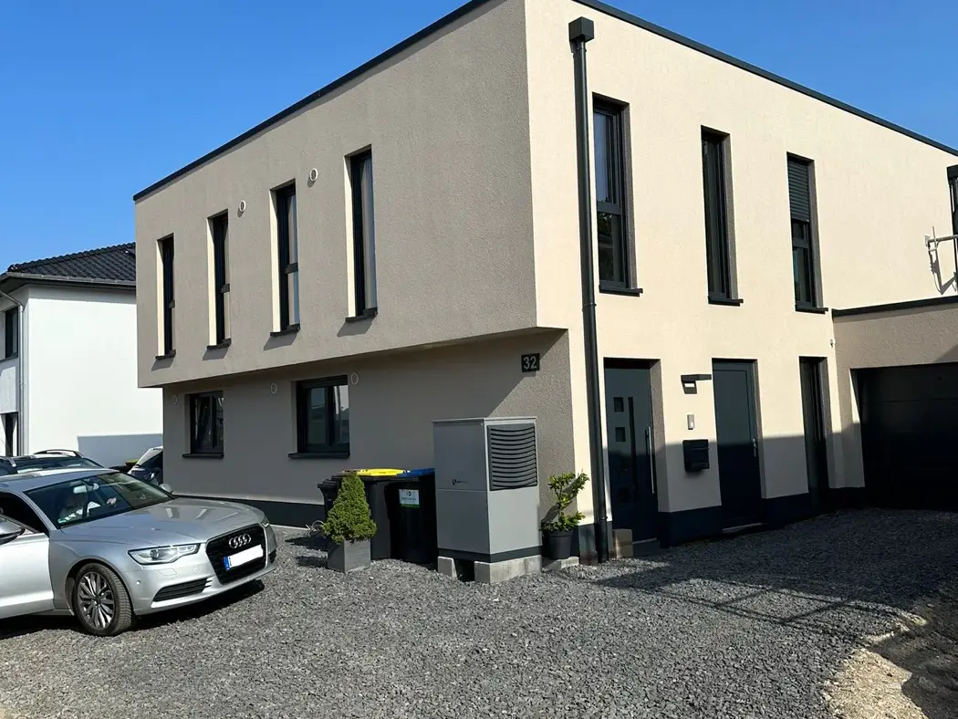 Fertiges zweigeschossiges Haus mit Flachdach und anthrazitfarbenen Fenstern