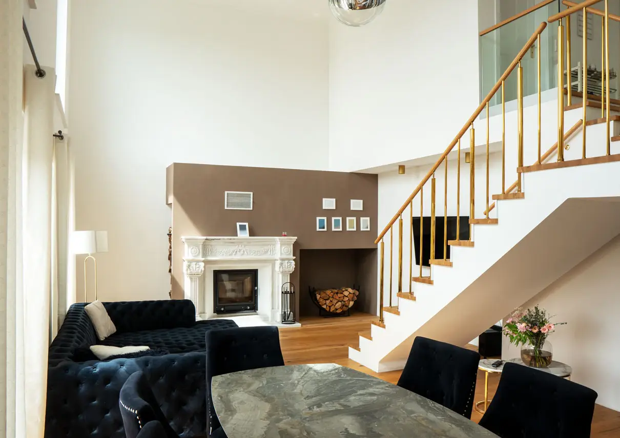 Wohnzimmer mit Kamin unter dem Luftraum, Treppe mit Holzgeländer