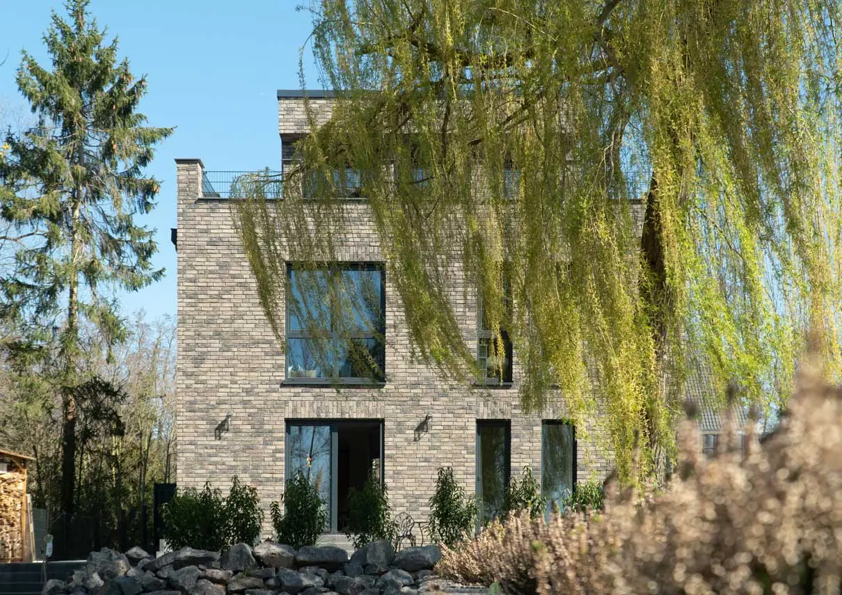 Klinkerfassade von BS21 im Frühjahr, gerahmt von Bäumen