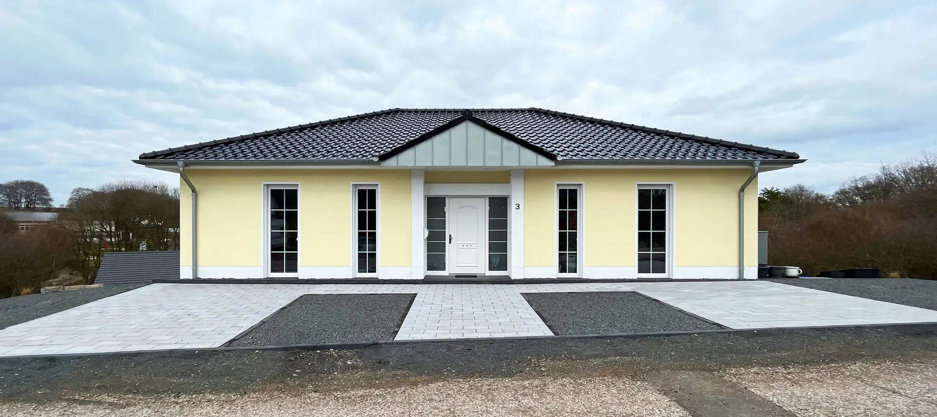 Bungalow DL21 mit Walmdach, symmetrischer Eingangsfront und hohen Sprossenfenstern