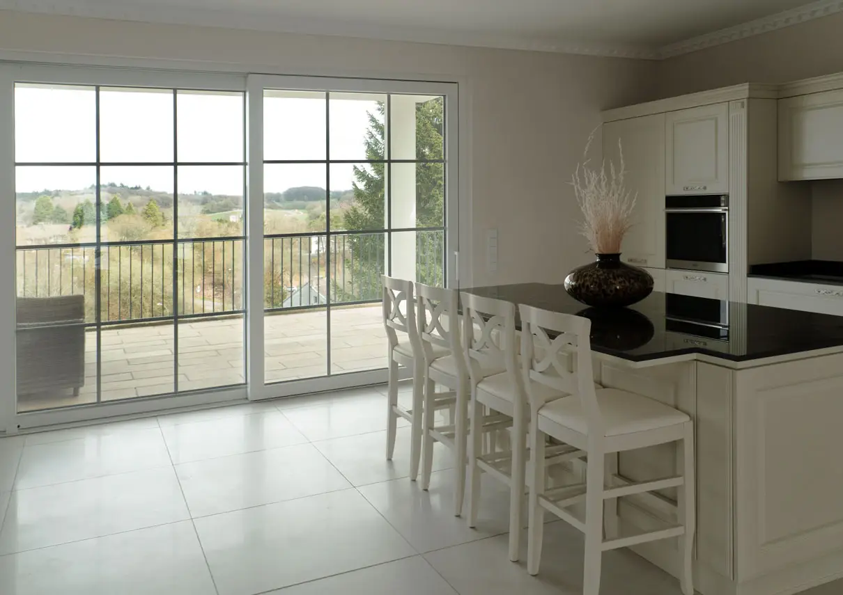 Landhausküche mit Theke vor großen Sprossenfenstern und Blick ins Tal