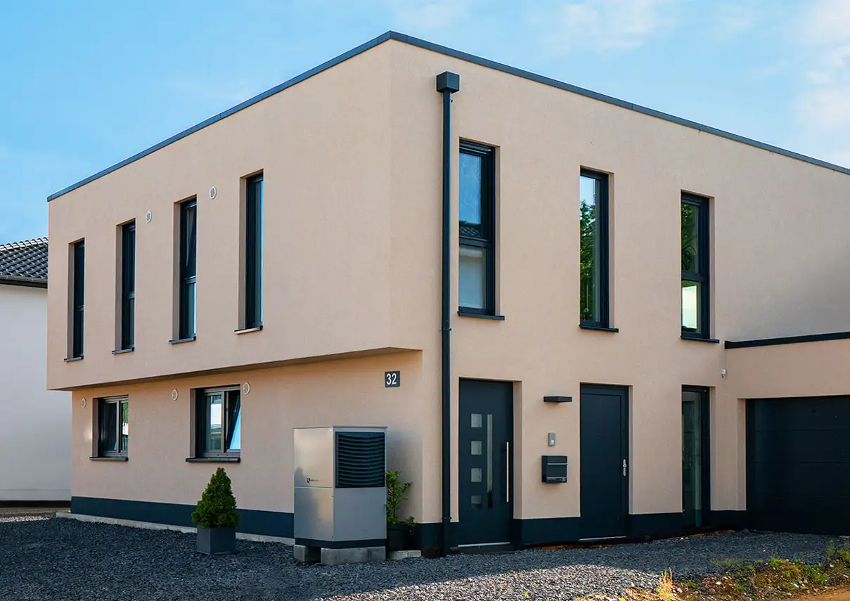 Kubisches Zweifamilienhaus FB21 mit hellem Putz, Flachdach und schmalen hohen Fenstern