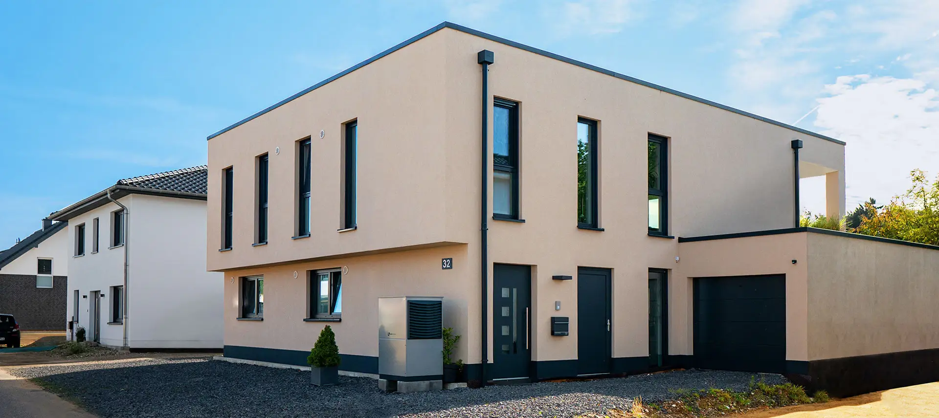 Kubisches Zweifamilienhaus FB21 mit hellem Putz, Flachdach und schmalen hohen Fenstern