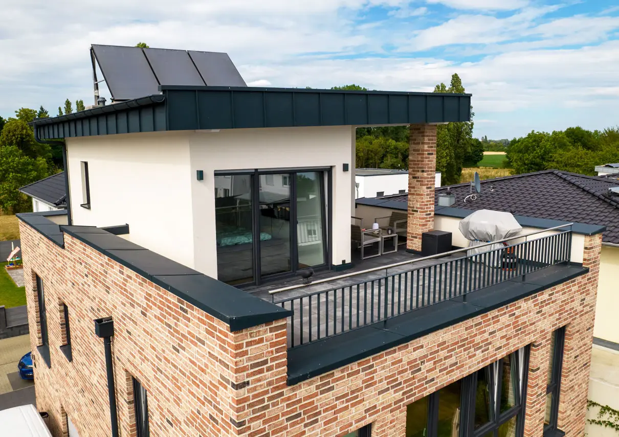 Dachterrasse der Obergeschosswohnung mit Metallgeländer und Solarthermie