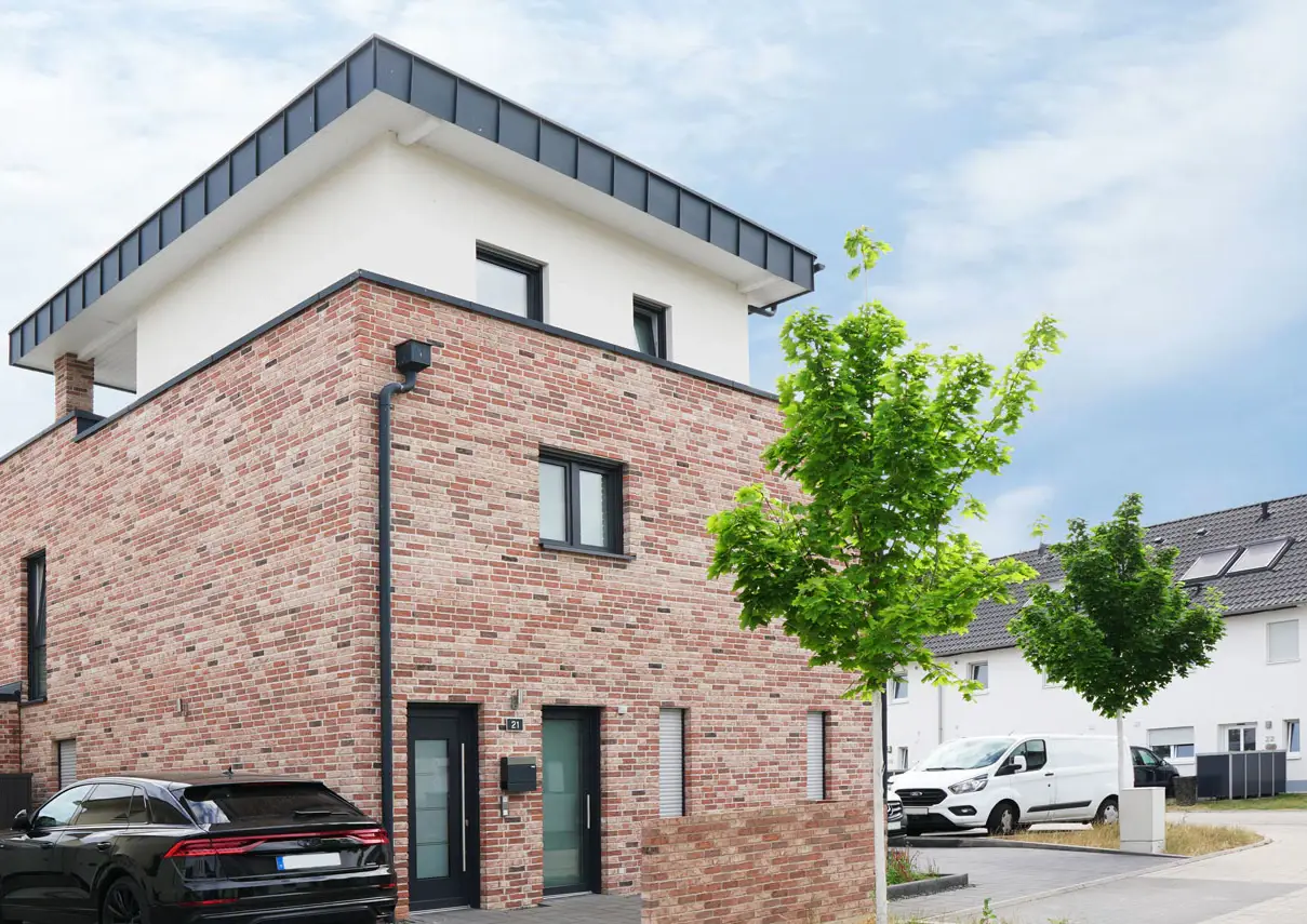 Zweifamilienhaus FK19 mit rotem Klinker, weißem Staffelgeschoss und flach geneigtem Pultdach
