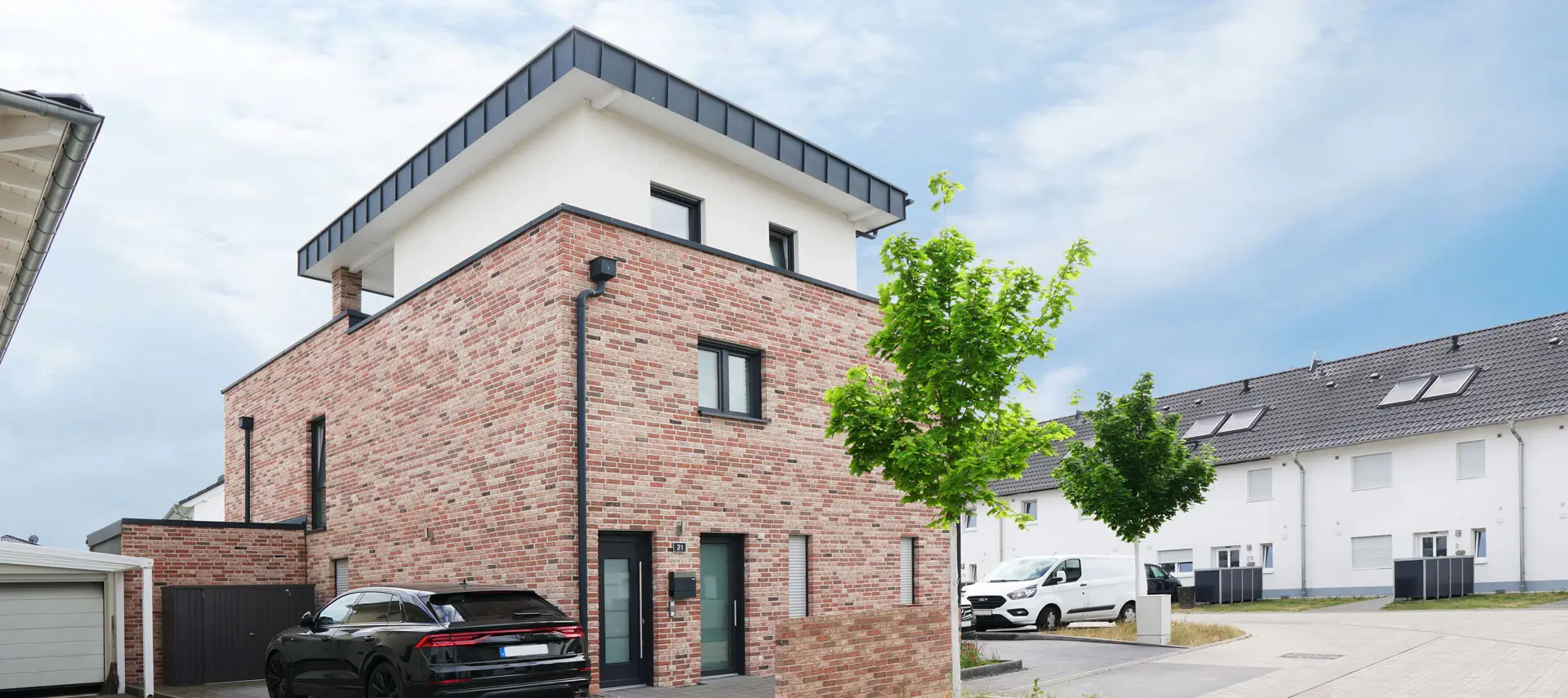 Zweifamilienhaus FK19 mit rotem Klinker, weißem Staffelgeschoss und flach geneigtem Pultdach