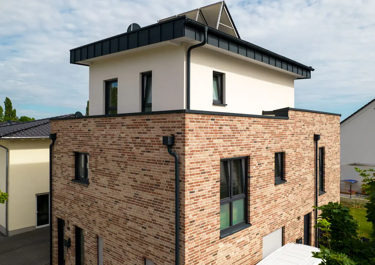 Klinkerfassade von FK19 mit weiß verputztem Staffelgeschoss