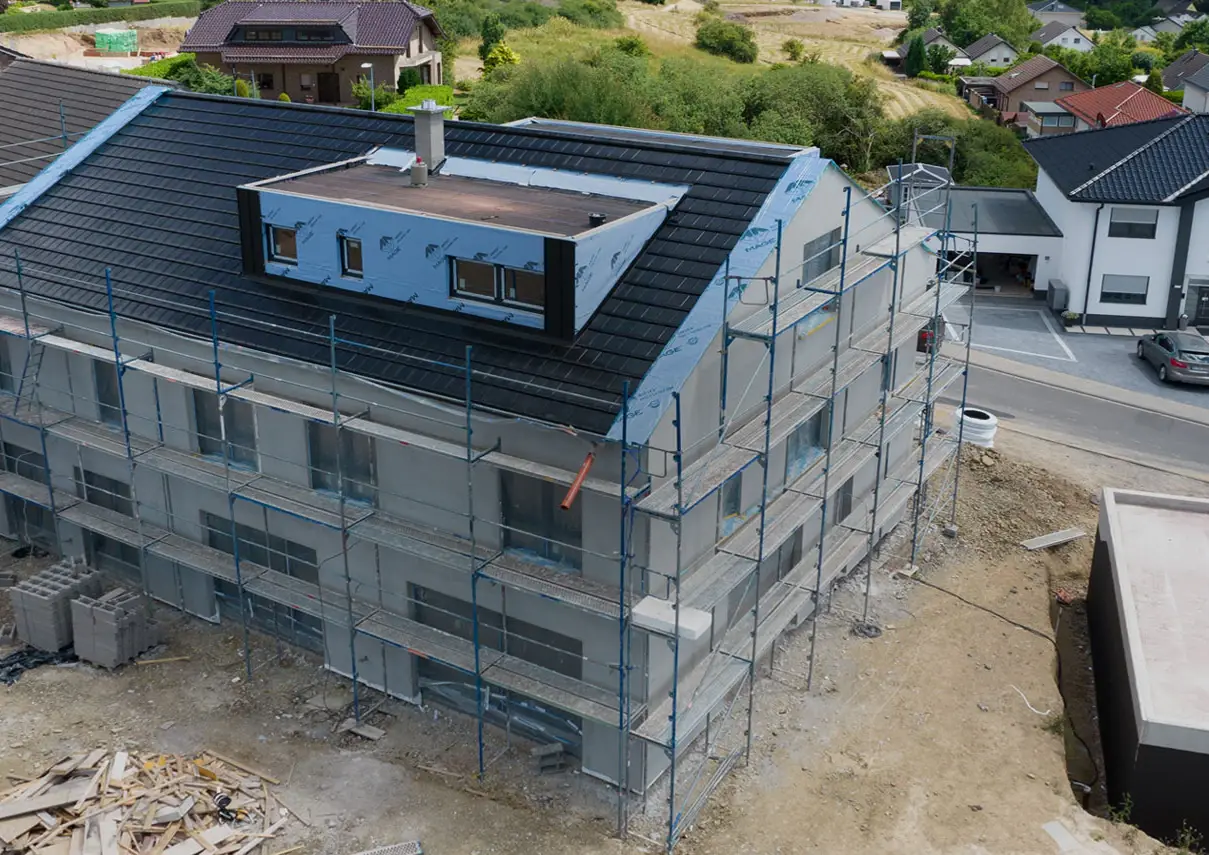 Luftbild von NF22 im Rohbau: Zweifamilienhaus mit Satteldach und Gaube in Hanglage