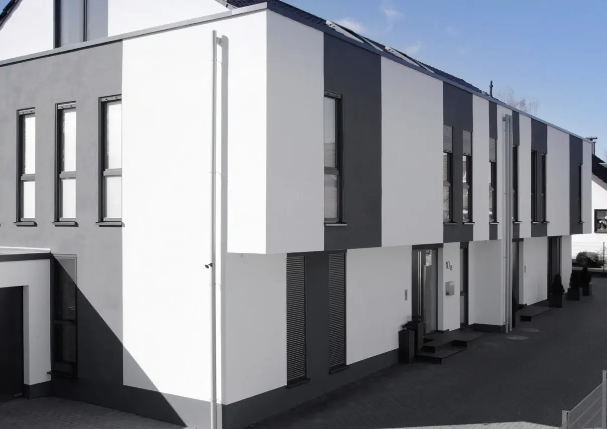 Doppelhaus ZW18 in Weiß und Anthrazit: Flachdachbau mit zurückgesetztem Satteldach und Attika