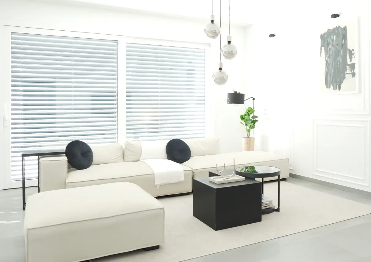 Helles Wohnzimmer mit weißem Sofa und großem Fenster